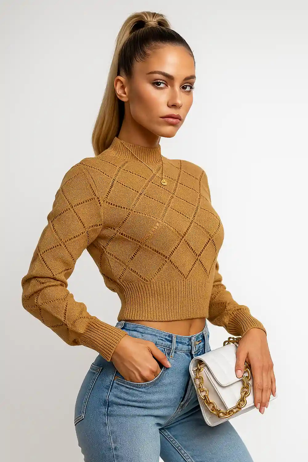 Women's camel knit sweater with diamond texture, paired with light jeans and white handbag