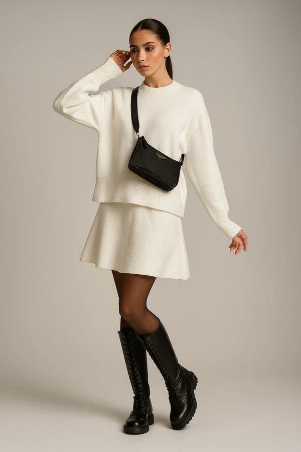 Elegant white knit sweater and skirt set for women with black boots and shoulder bag
